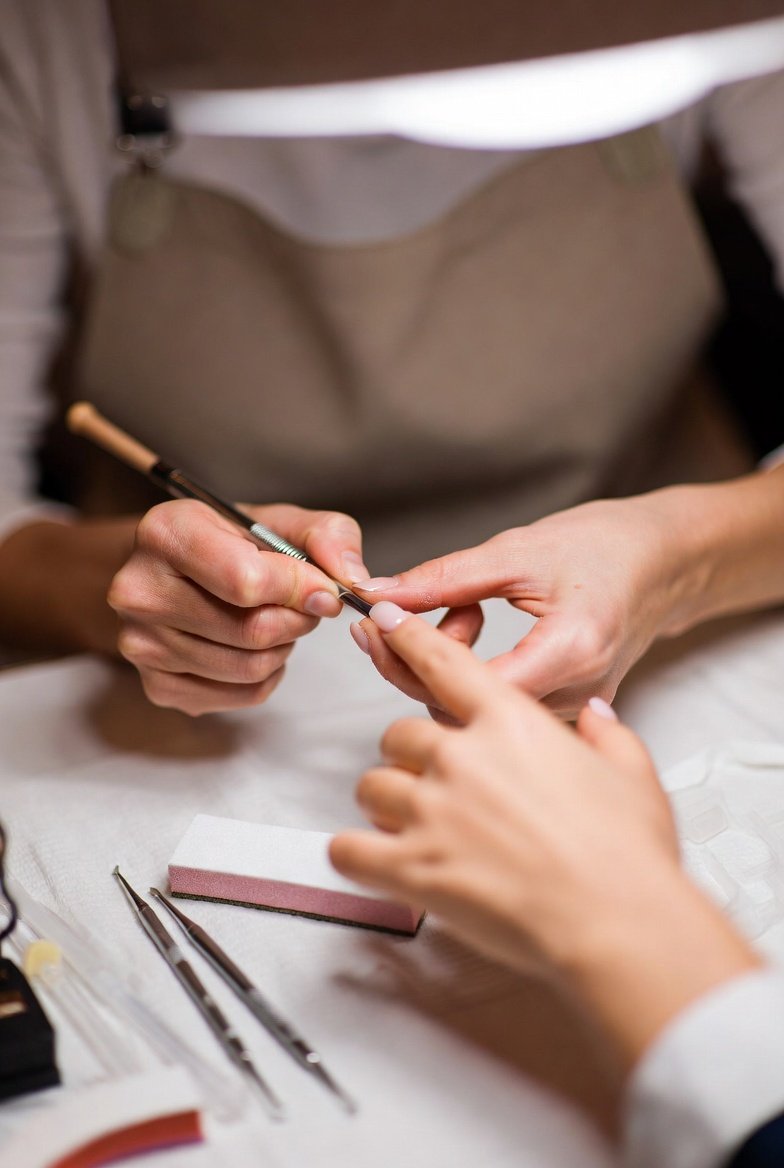 Nail technician demonstrating a practical nail technique during a skills assessment